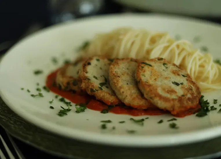 Oval tabakta kızarmış kroket, kırmızı sos ve püre şeridi